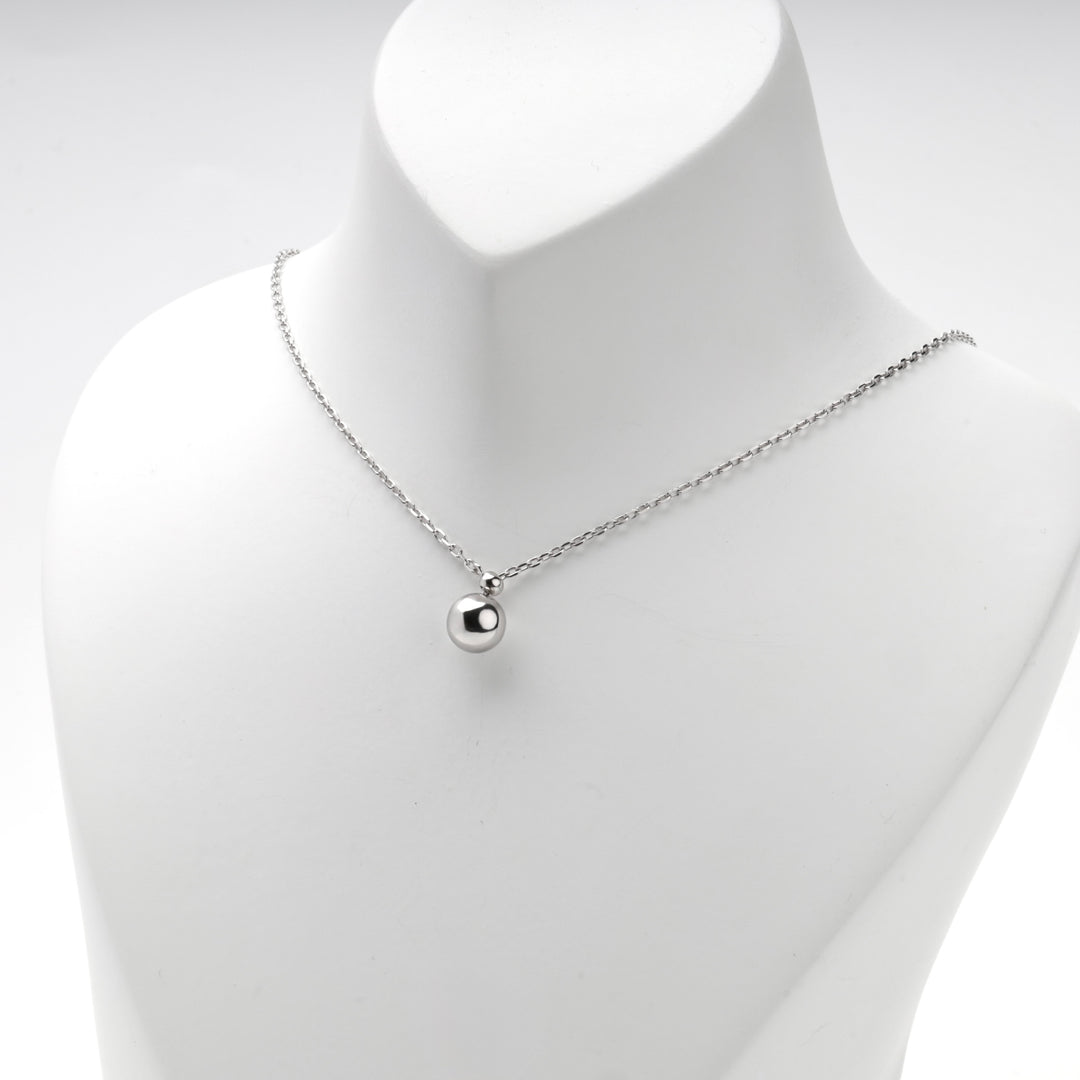 Necklace worn short with the polished ball sitting just below the collarbone