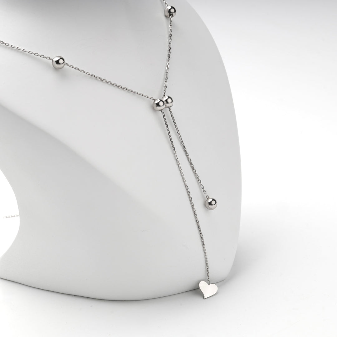 Silver 925 beaded Y necklace with a heart drop on a display bust