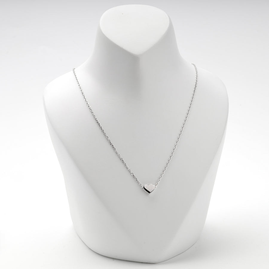 Heart necklace worn at a longer setting on a white display bust