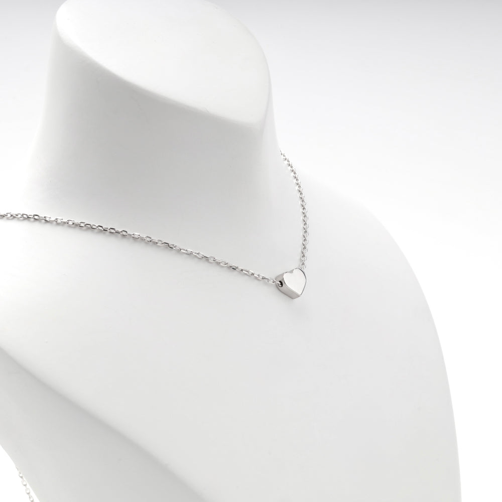 Silver heart necklace worn short, angled view