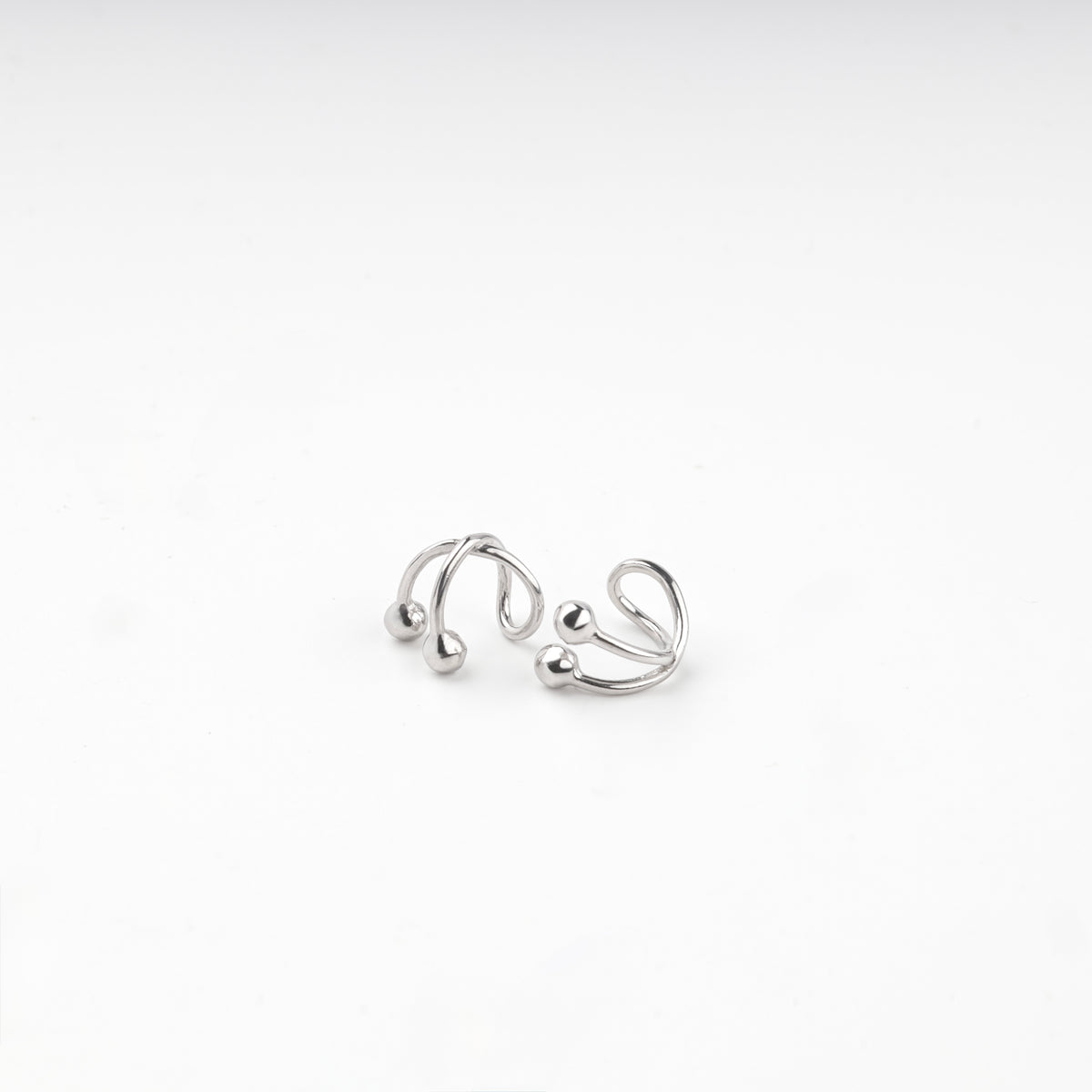Pair of silver 925 crossover ear cuffs with polished ball ends