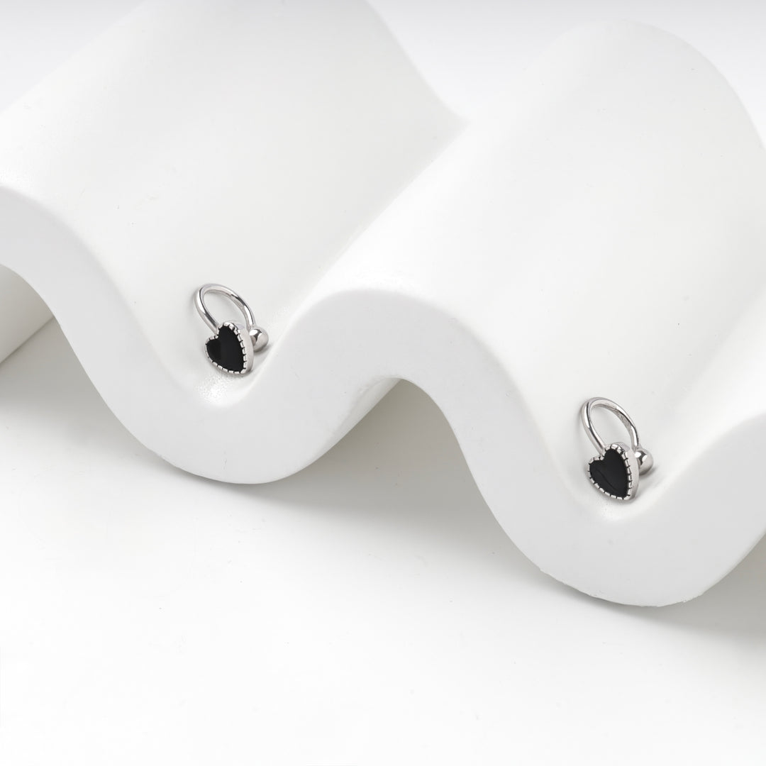 Silver 925 hoop earrings with black hearts on a white wave stand
