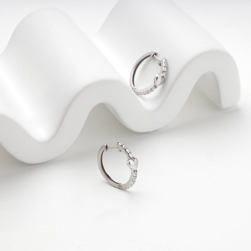 Silver 925 huggie hoops showing the cubic zirconia along the outer edge