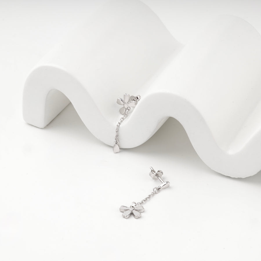 Silver 925 flower drop stud earrings on a white wave stand