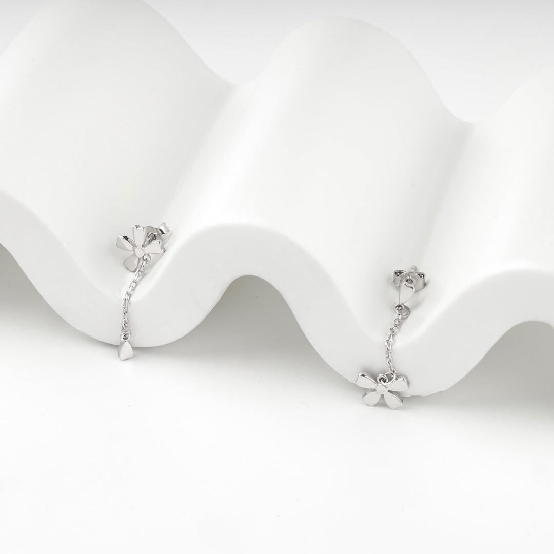 Both silver 925 flower drop earrings shown together on a wave stand