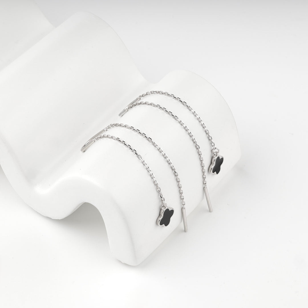 Silver 925 clover threader earrings on a white stone surface