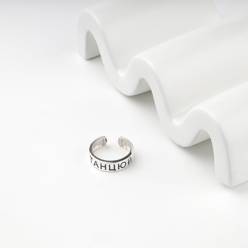 Open silver ring engraved with a Ukrainian word on a white surface