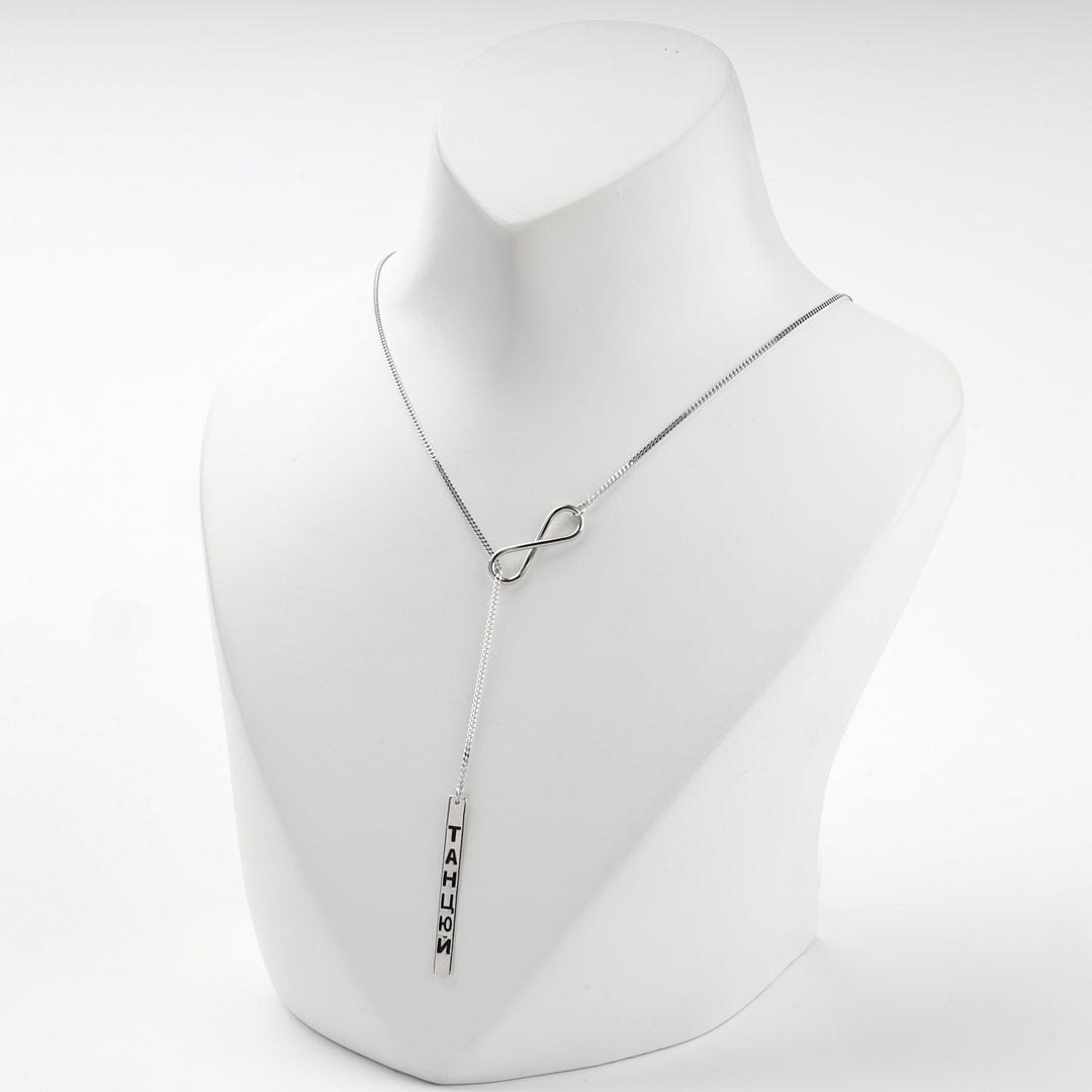 Silver infinity necklace with the engraved bar hanging at the front