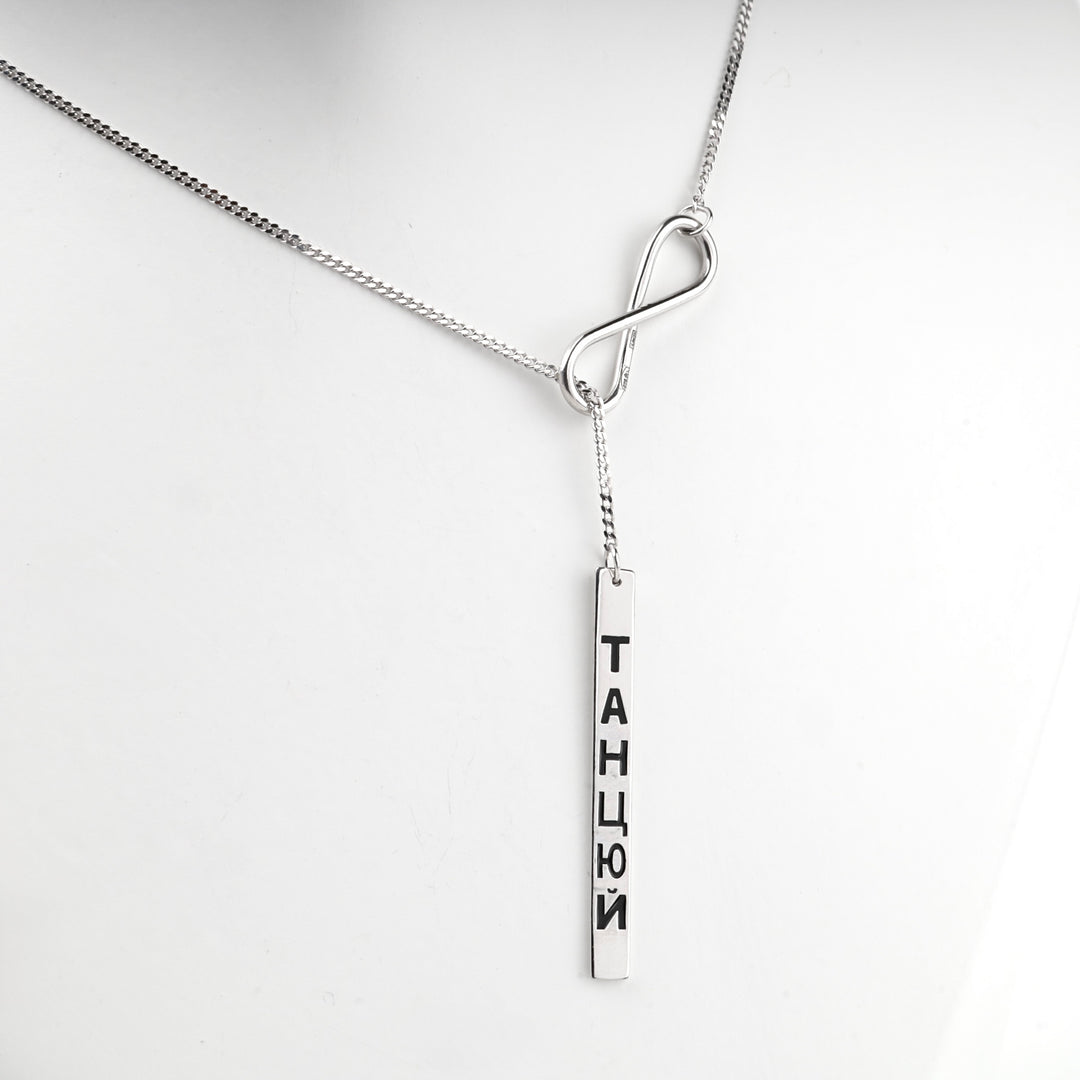 Close view of the silver infinity element on the curb chain