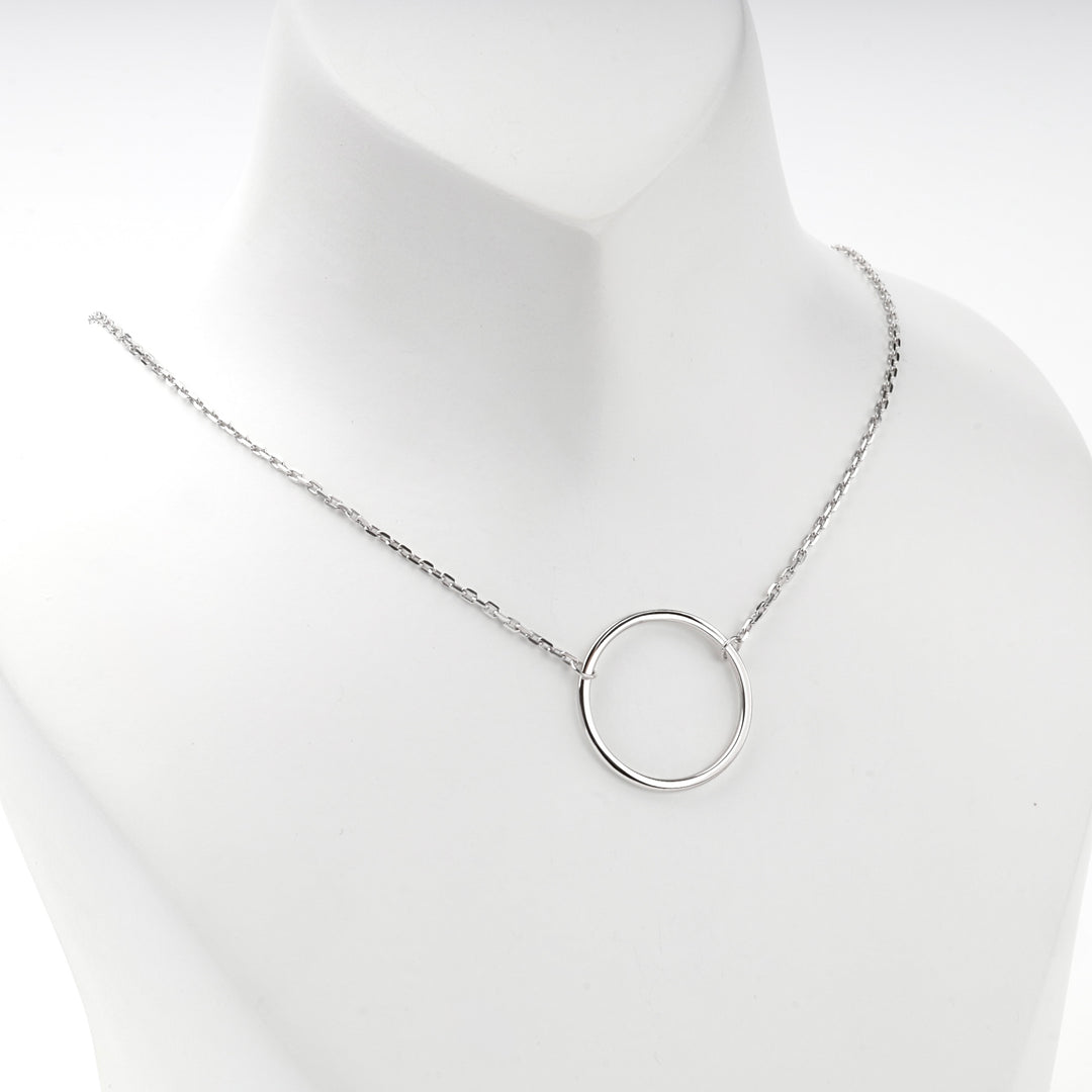 Open circle necklace worn at the base of the neck, front view