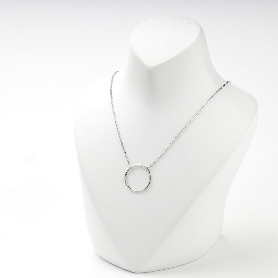 Silver open circle necklace centered on a white display bust
