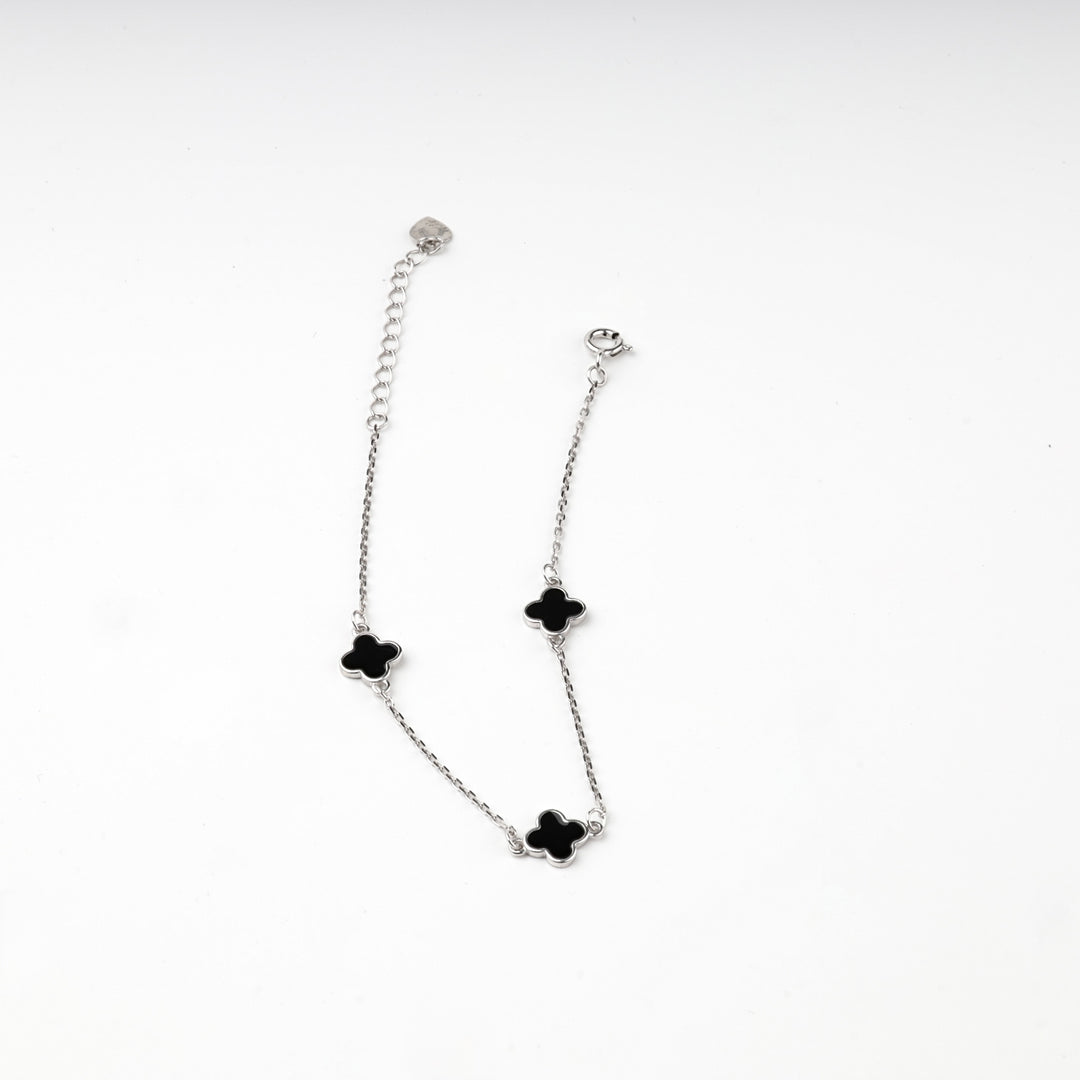 Silver 925 black clover bracelet laid flat with clasp, extender chain and heart tag