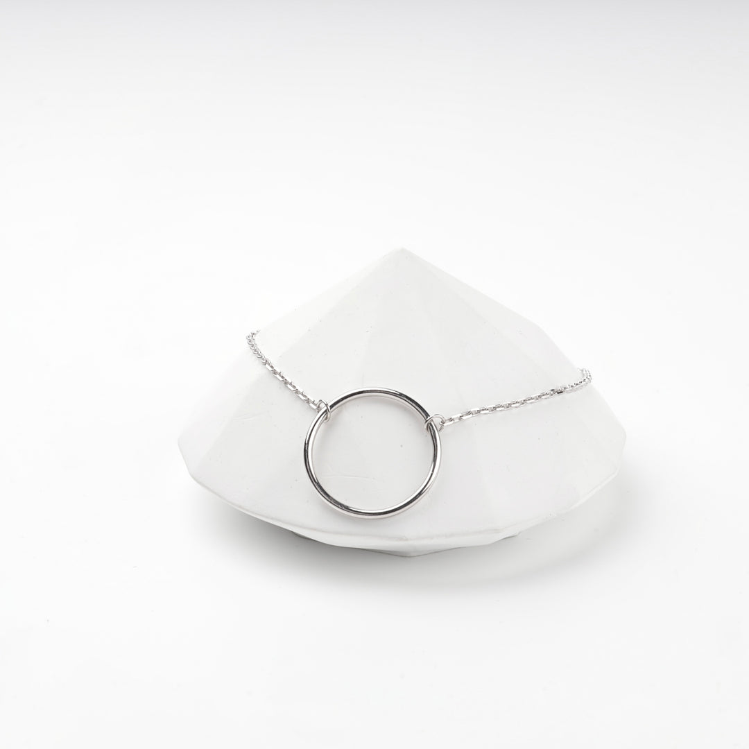 Silver 925 open circle bracelet resting on a white faceted prop