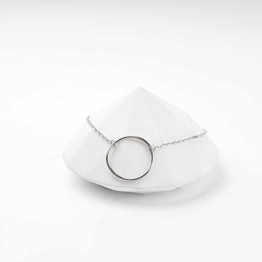 Silver 925 open circle bracelet resting on a white faceted prop