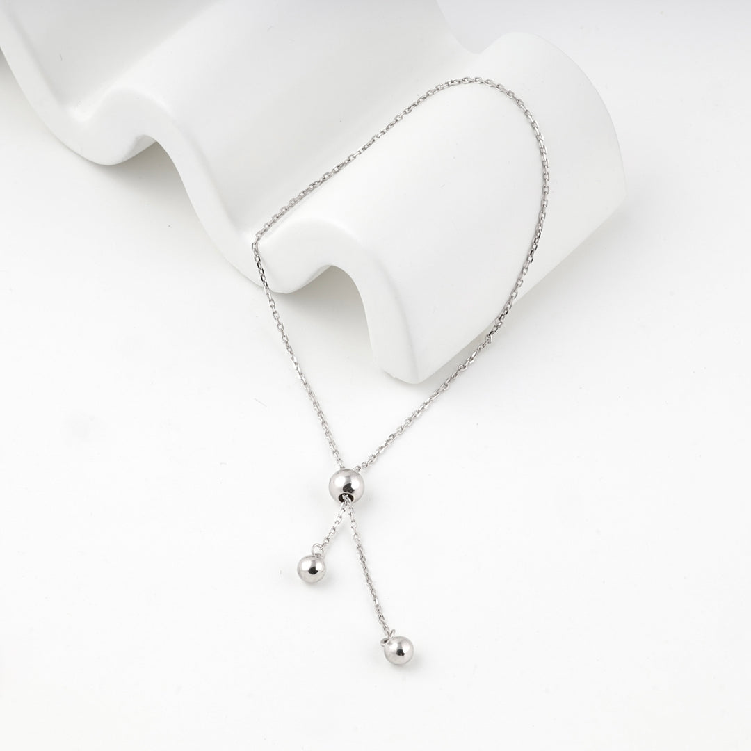 Silver 925 bolo bracelet draped over a white wave-shaped display block