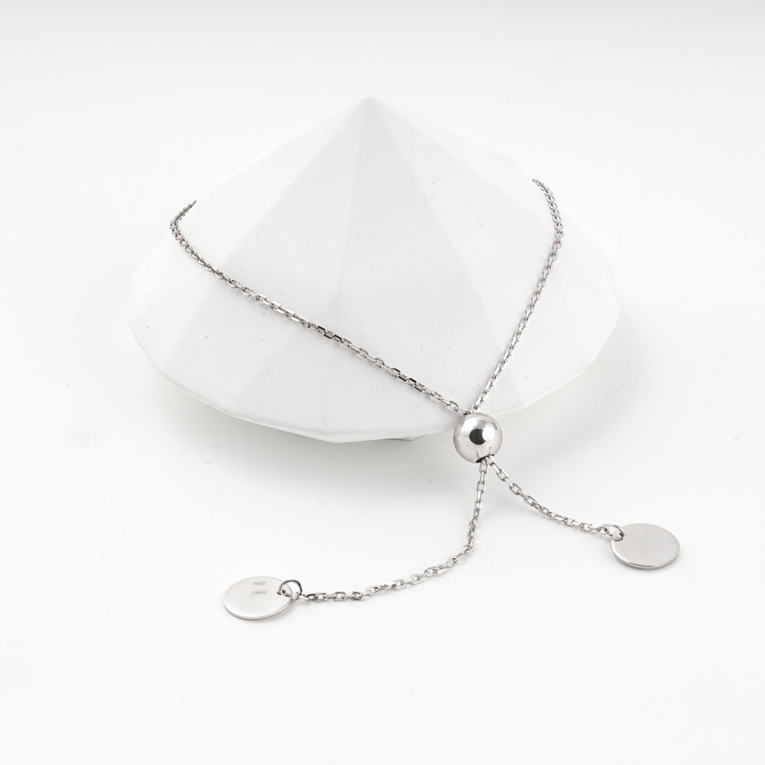 Silver 925 adjustable bracelet with two disc charms on a white faceted prop
