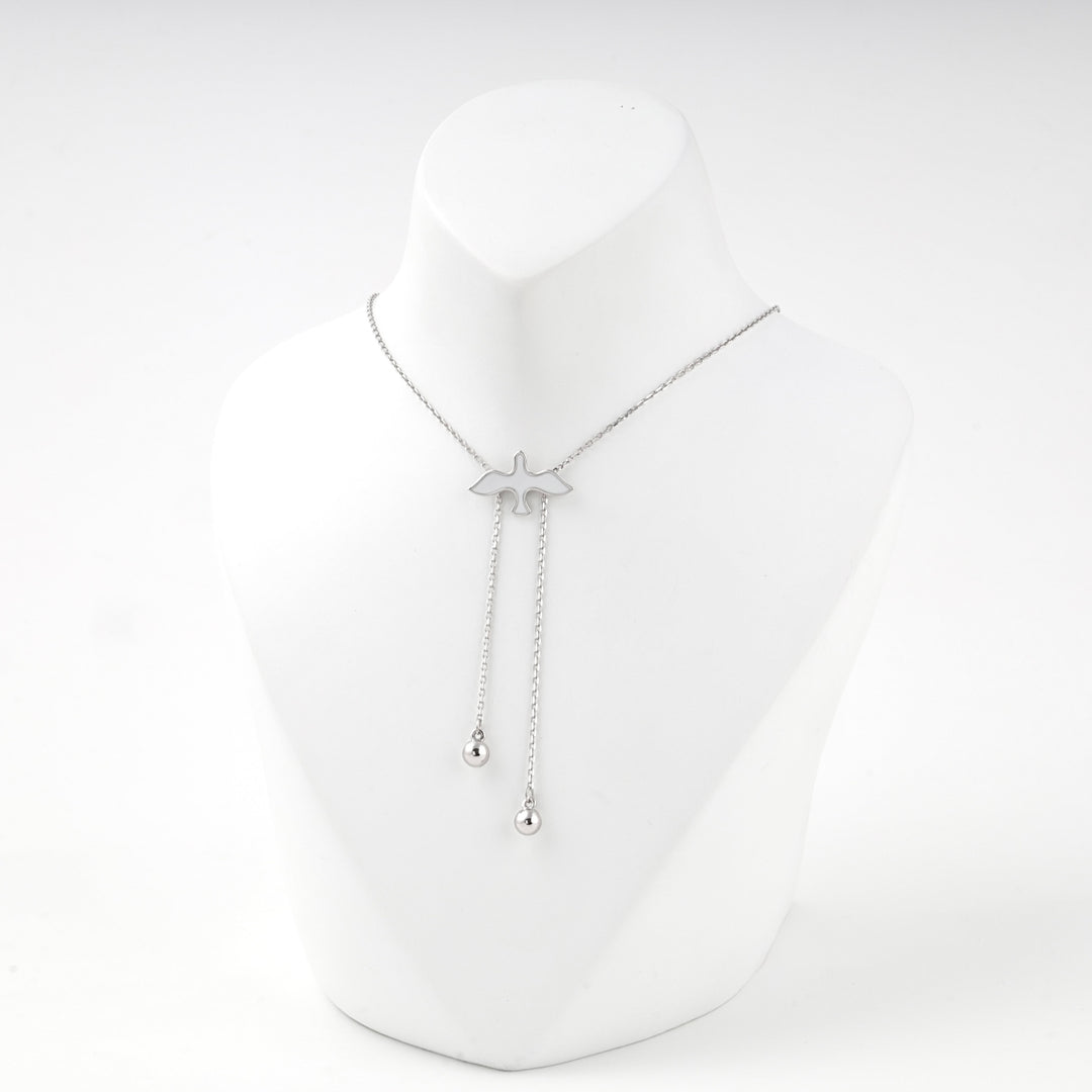 Silver bird necklace with two ball drops on a white display bust