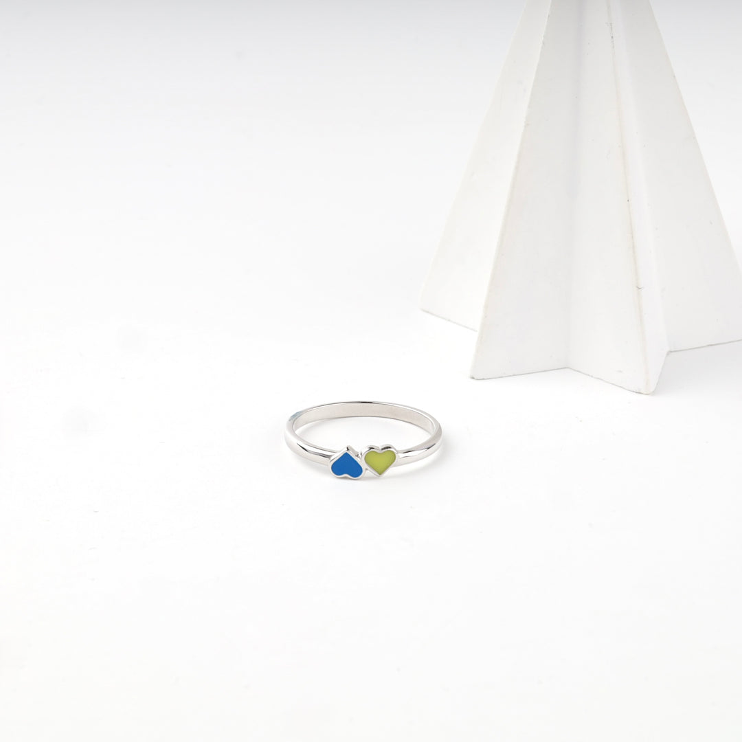 Enamel heart ring beside a white display cone