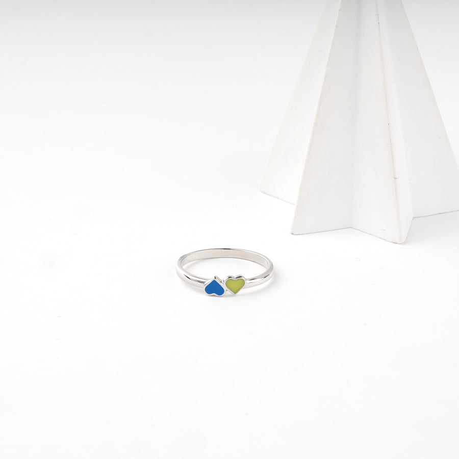 Enamel heart ring beside a white display cone