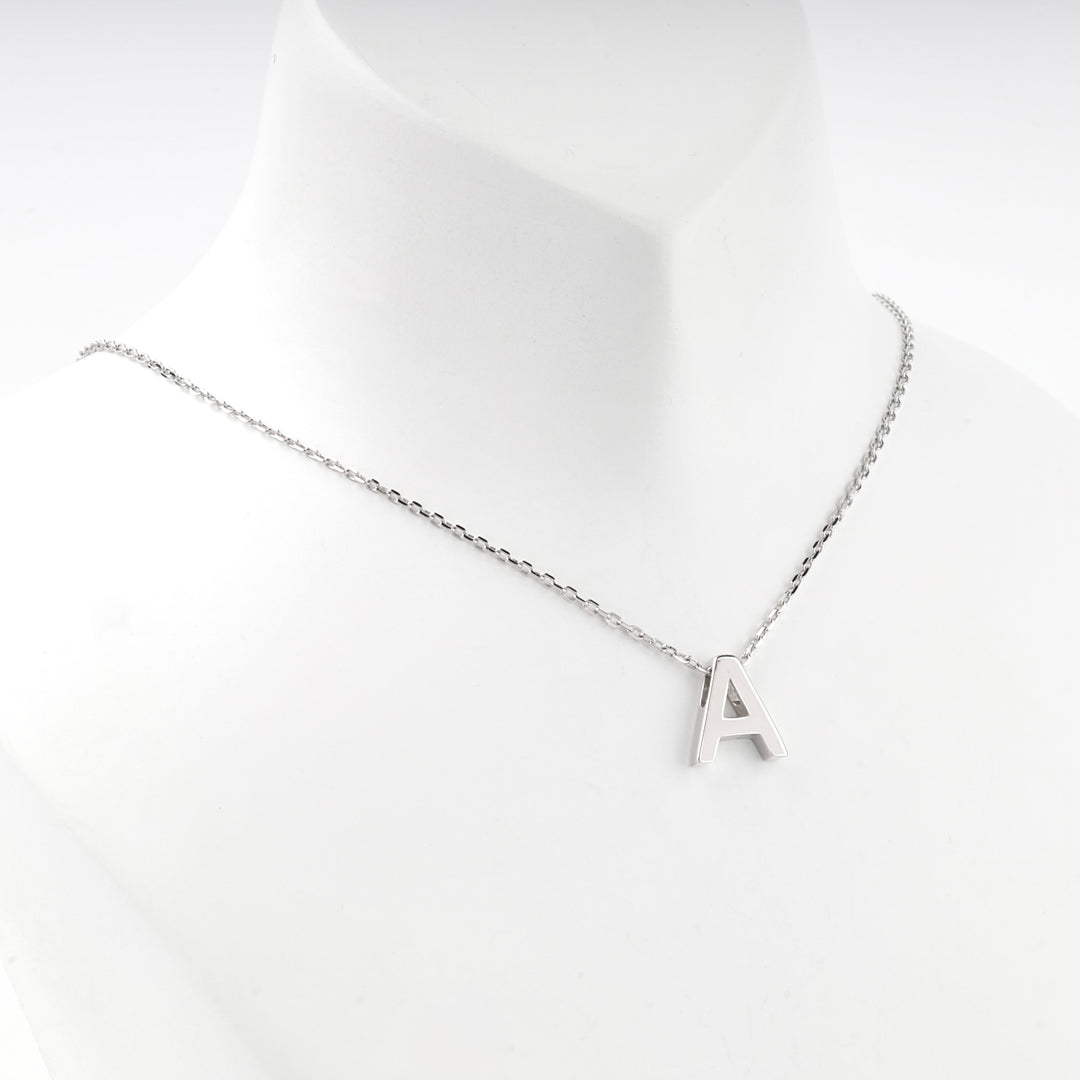 Letter A necklace worn at the base of the neck, front view