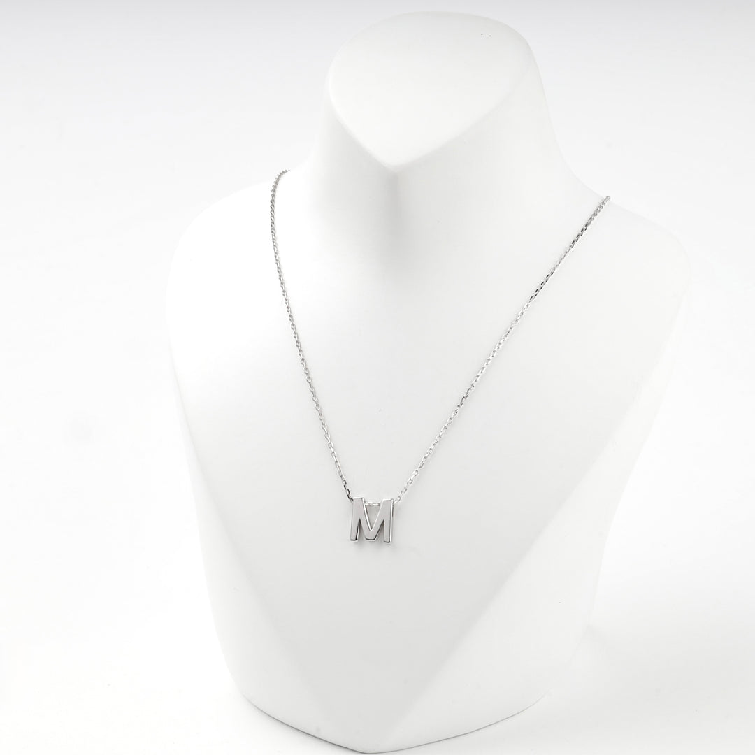 Letter M initial necklace worn on a white display bust