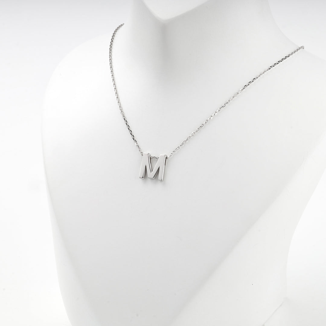 Close view of the silver letter M pendant on the fine anchor chain