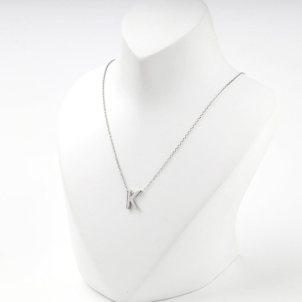 Letter K initial necklace worn on a white display bust