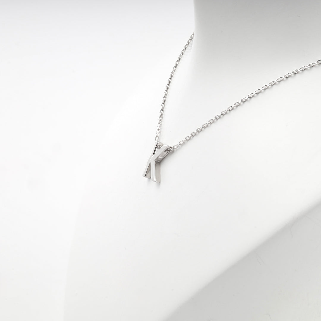 Angled view of the letter K pendant hanging from the chain