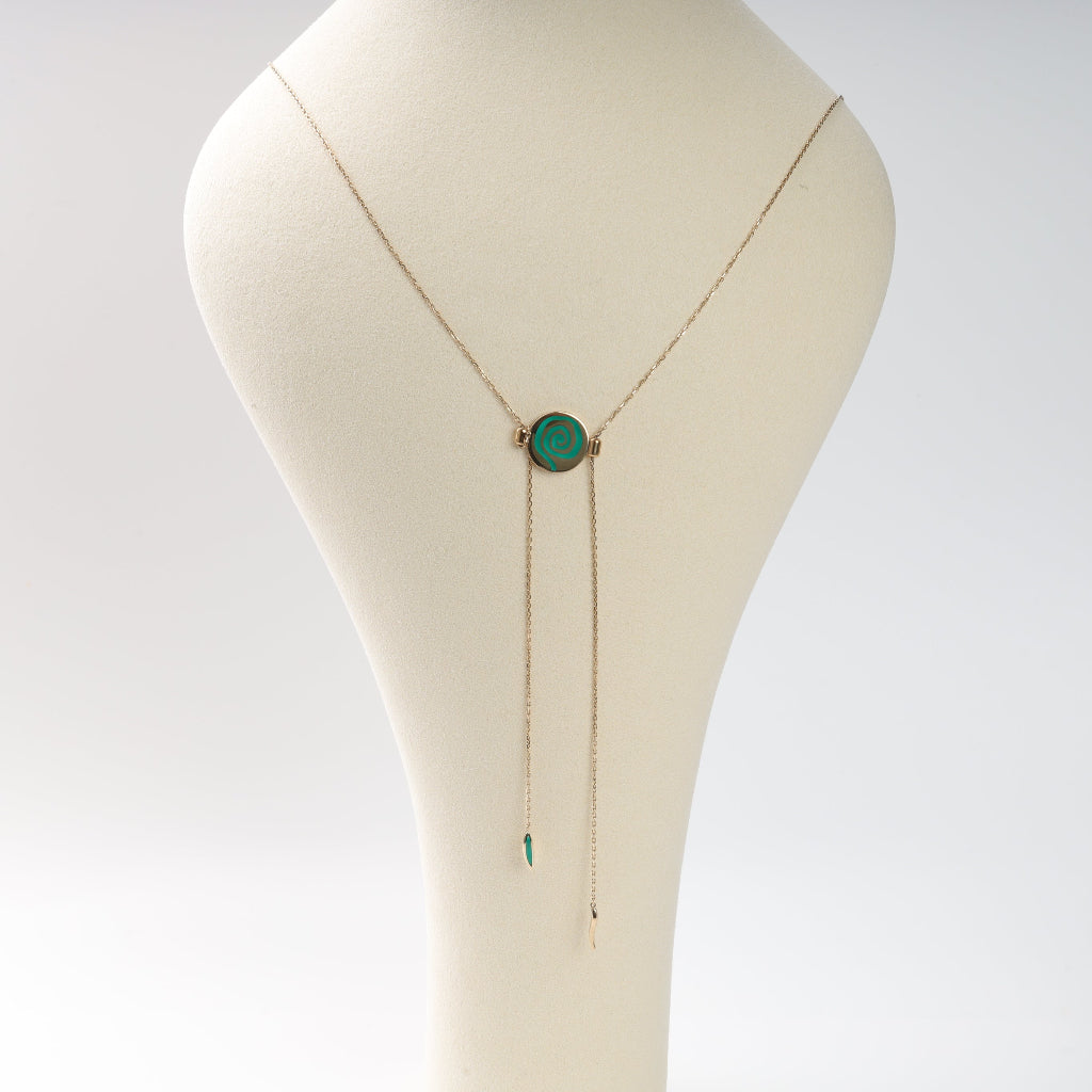 Necklace with a green pendant on a mannequin bust against a white background
