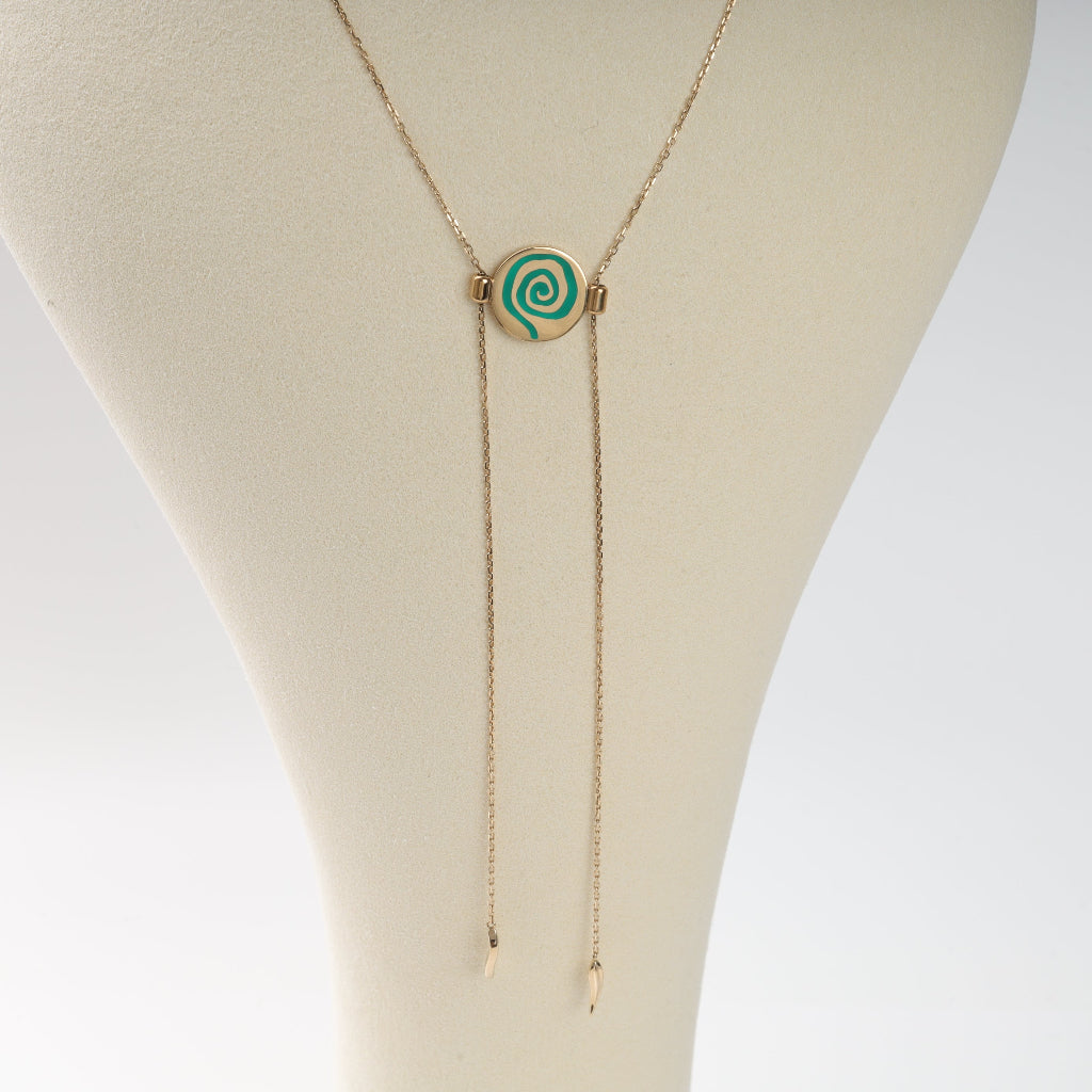 Necklace with a green spiral pendant on a mannequin bust.