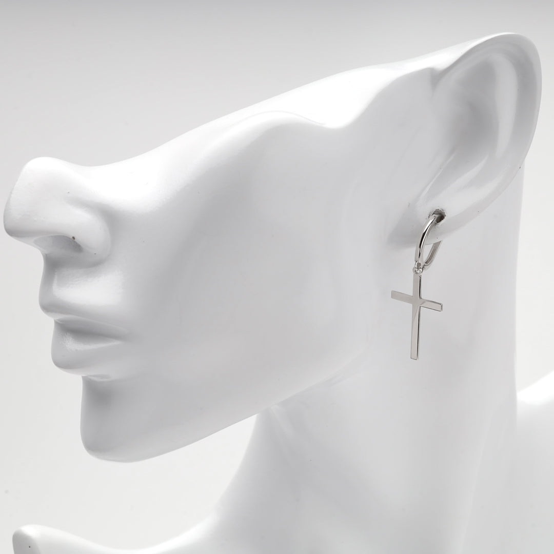 Close-up of the silver 925 cross hanging from the hinged hoop on a mannequin ear