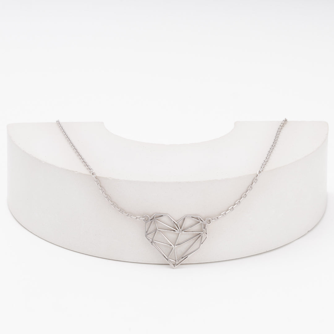 Silver geometric heart necklace laid flat on white background — Ukrainian Jewelry