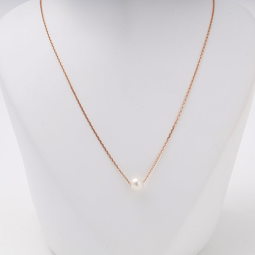 Close view of the white pearl set on the fine rose gold chain