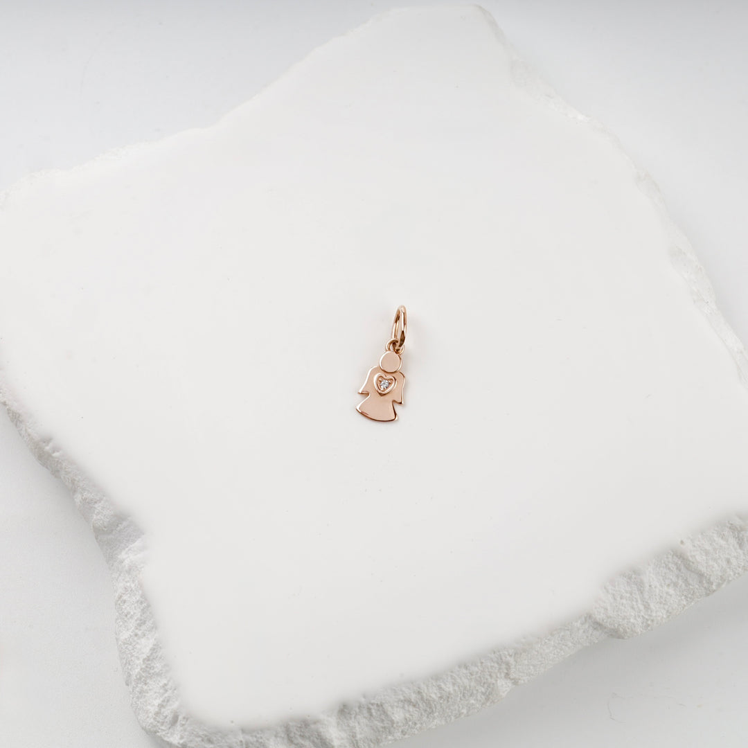 Small solid rose gold angel pendant with a heart and cubic zirconia, front view