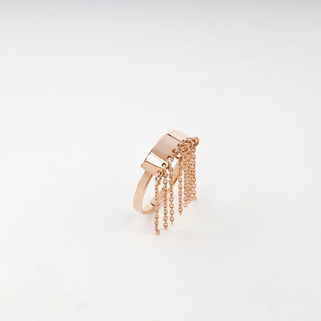 Rose gold fringe ring on white surface