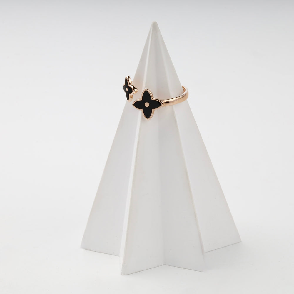 Rose gold ring black enamel flower on white prop