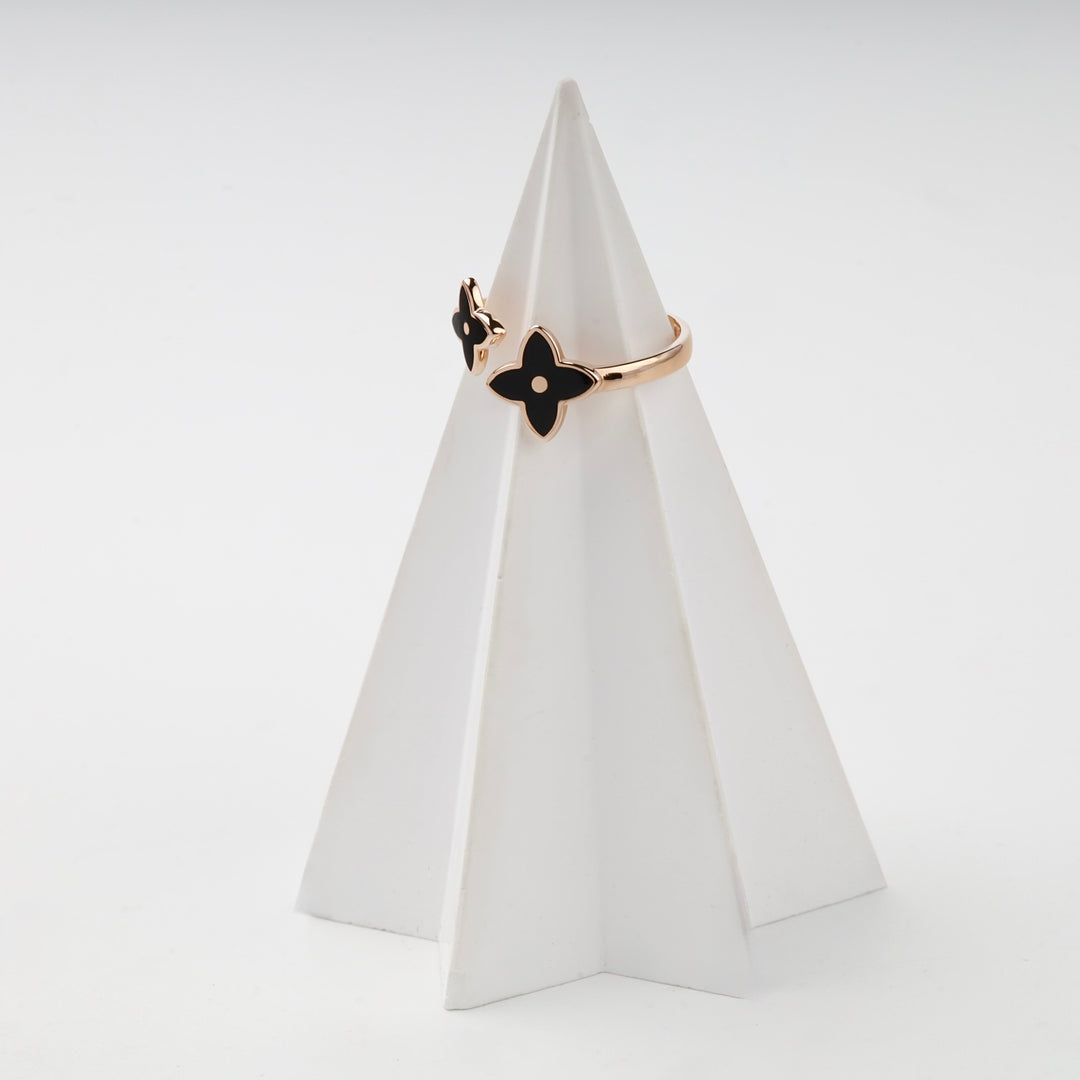 Rose gold ring black enamel flower on white prop