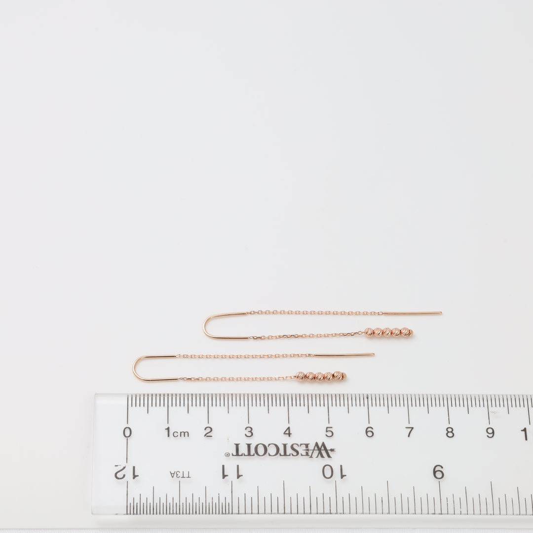 Rose gold threader earrings with faceted beads on ruler 8cm