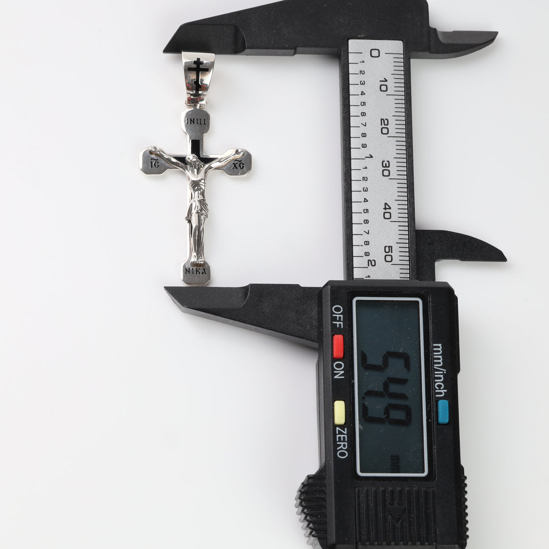 Silver Orthodox crucifix pendant measured with a caliper