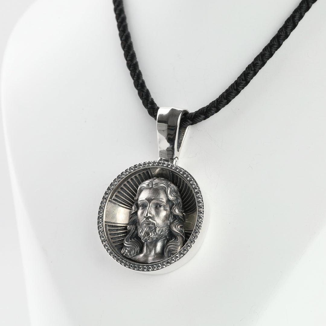 Religious silver medallion pendant with Jesus Christ, detail view