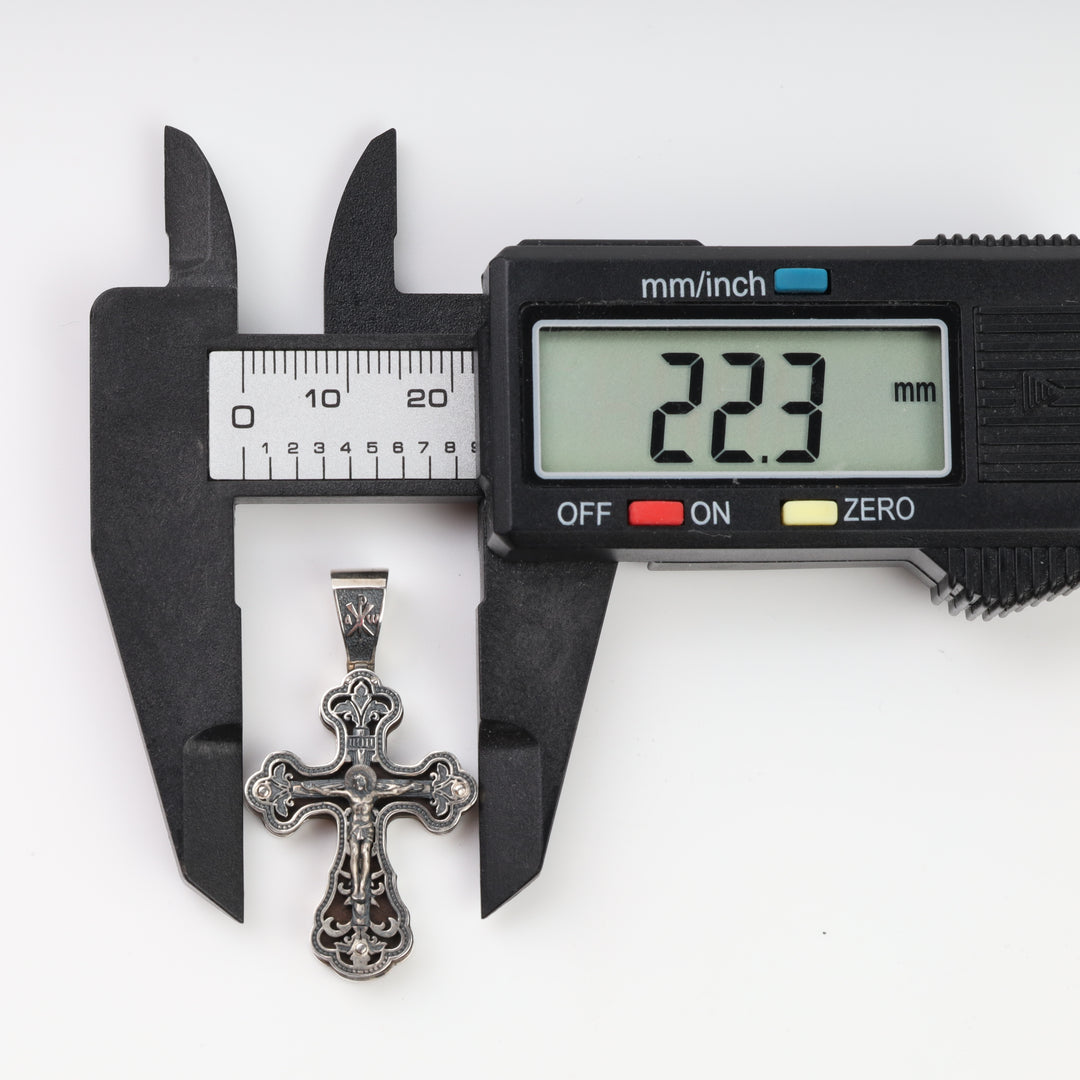Silver crucifix pendant width measured with a caliper at 22.3 mm
