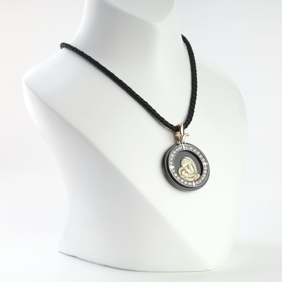 Gold and onyx Mother of God pendant with cubic zirconia halo, close-up