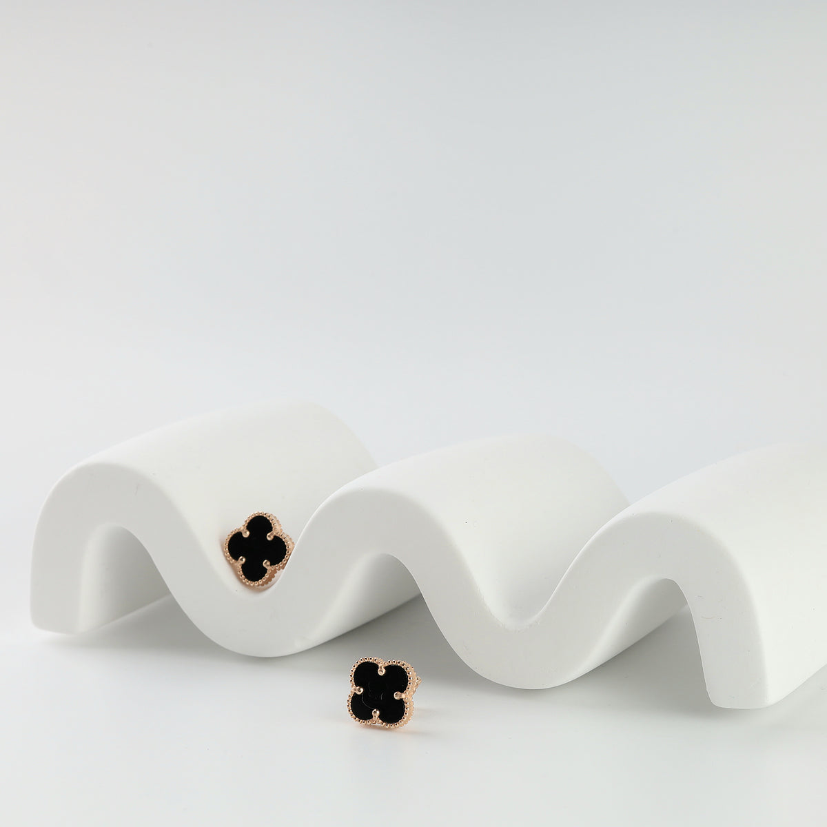 Rose gold four-leaf clover stud earrings with black onyx and beaded edge