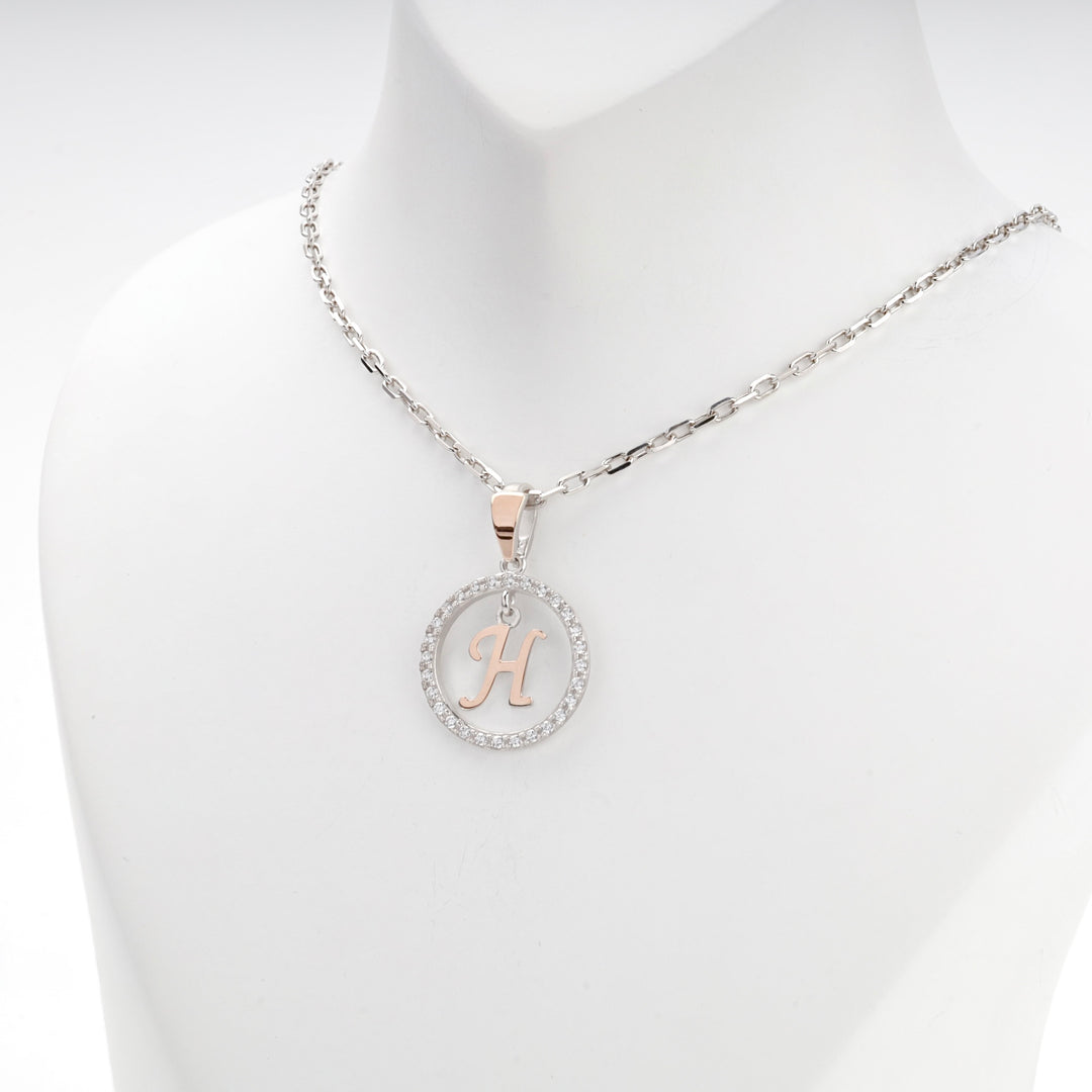 Close view of the cubic zirconia circle framing the rose gold letter H