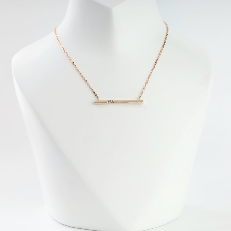 14K rose gold bar necklace with cubic zirconia on a display bust