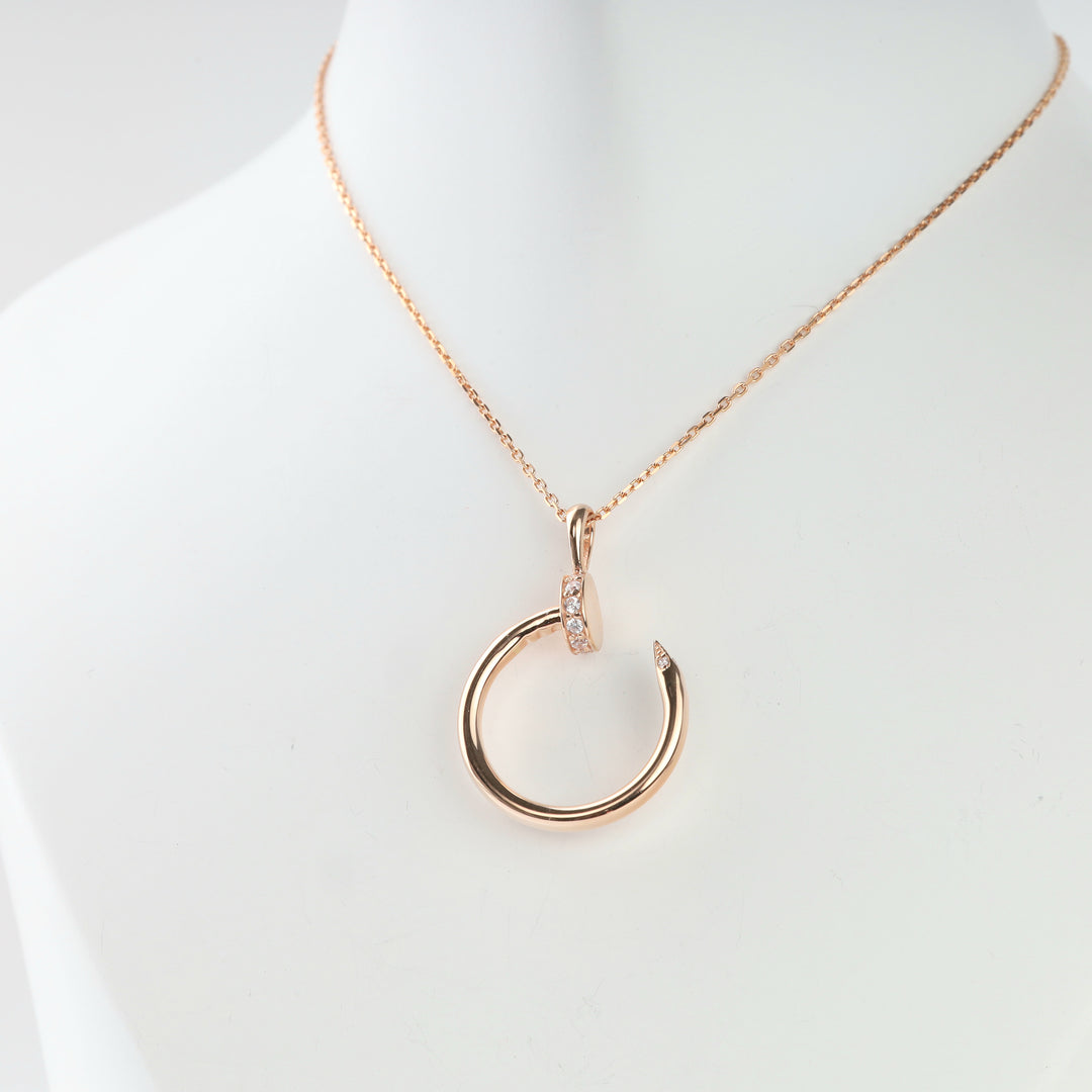 Rose gold nail pendant bent into an open circle