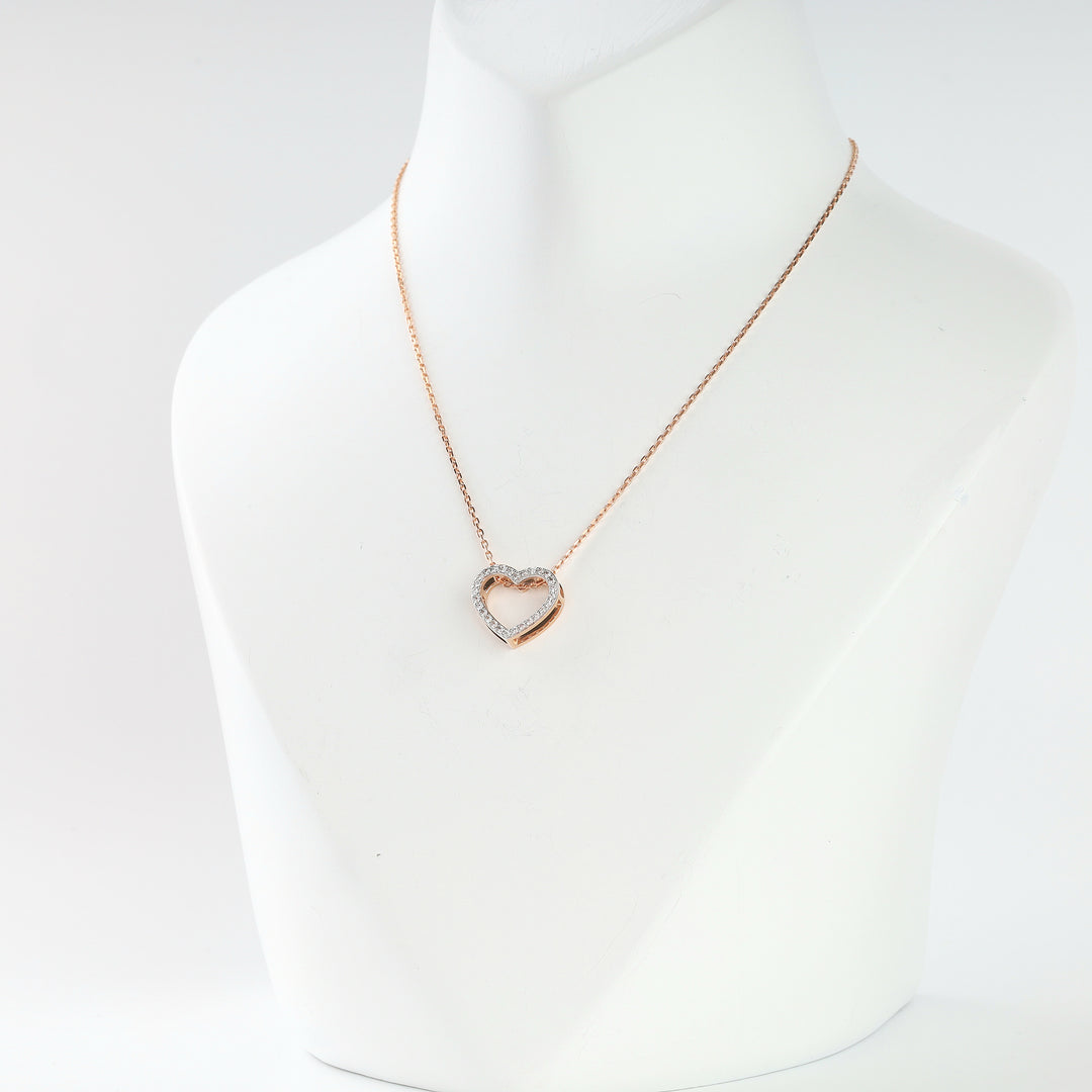 Rose gold open heart pendant with cubic zirconia on one side, detail