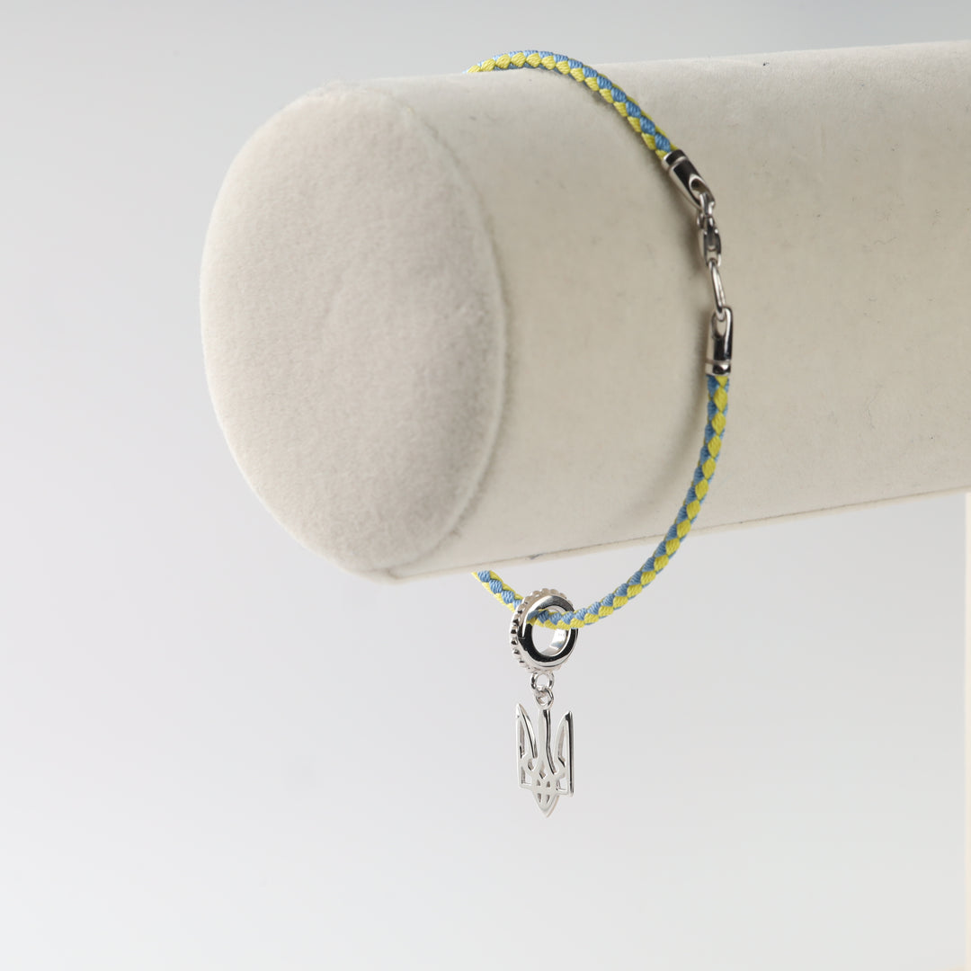 Tryzub cord bracelet displayed on a wrist stand