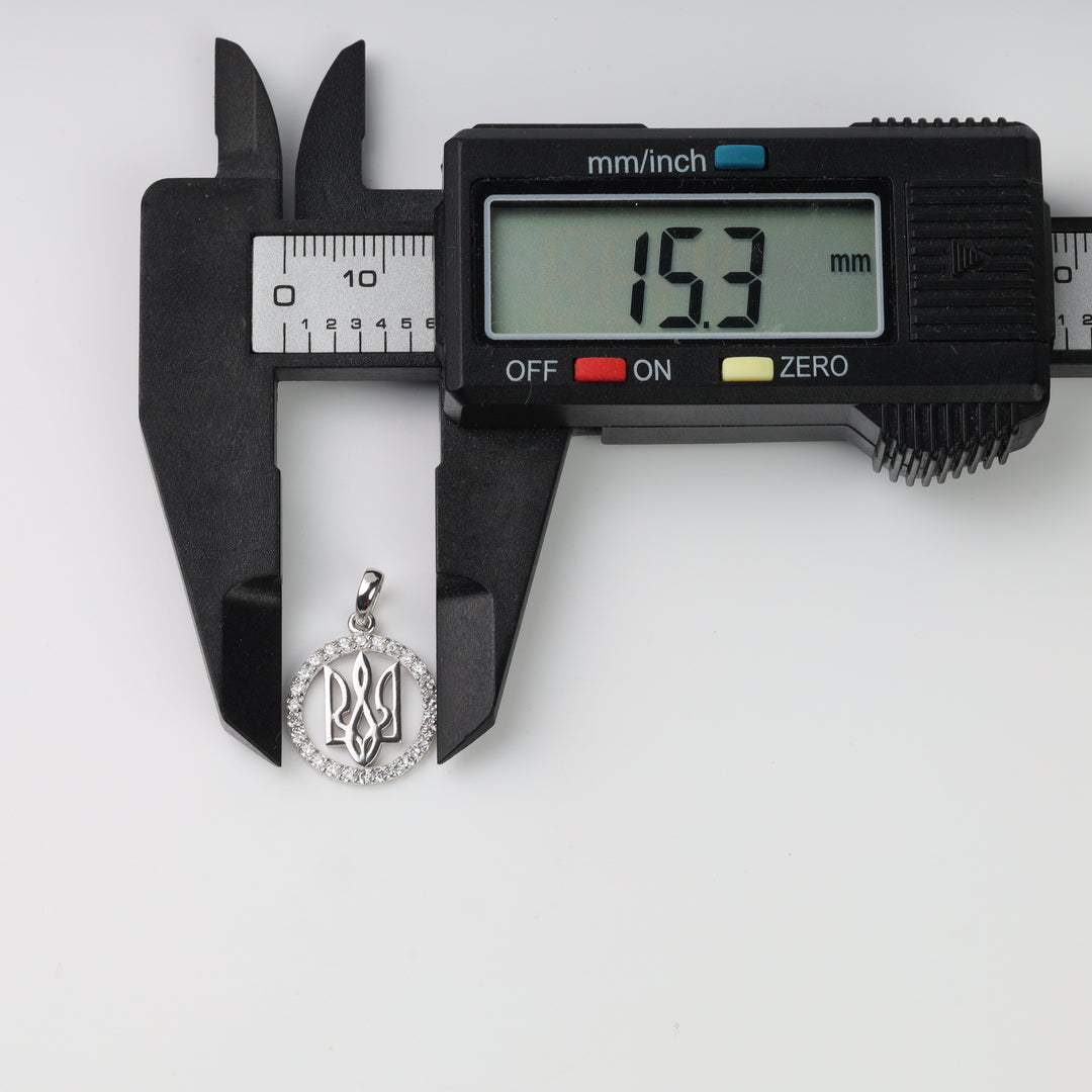 Caliper measuring the round silver Tryzub pendant at 15.3 mm wide