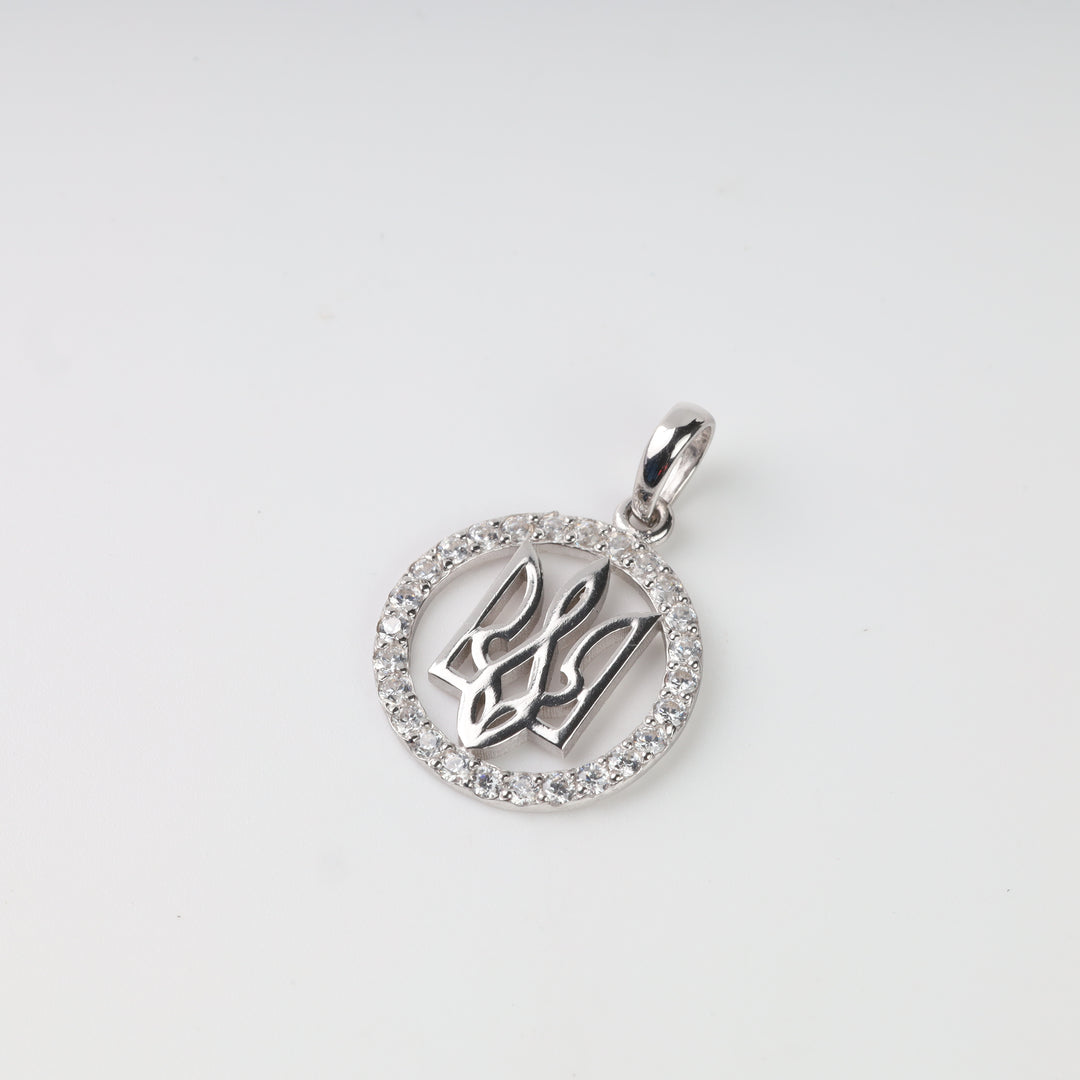Close-up of openwork Tryzub pendant with clear stone border and rhodium finish